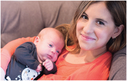 Close-up photo of Becca Mintz, lying on a sofa with her baby.
