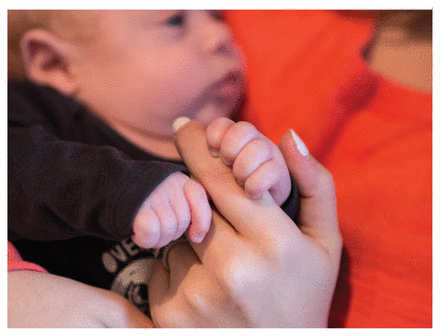 Close-up photo of Becca Mintz's baby's hands gripping her finger.